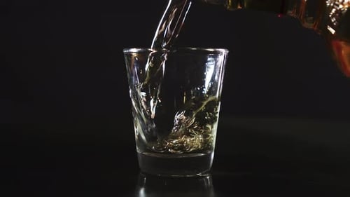 Silhueta de um copo de shot sendo preenchido com uísque