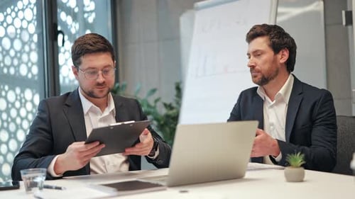 Two Businessmen Meeting to Review Key Performance Indicators