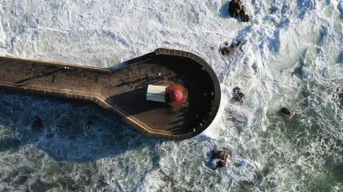 Aerial View of Lighthouse in the Midst of Dramatic Waves