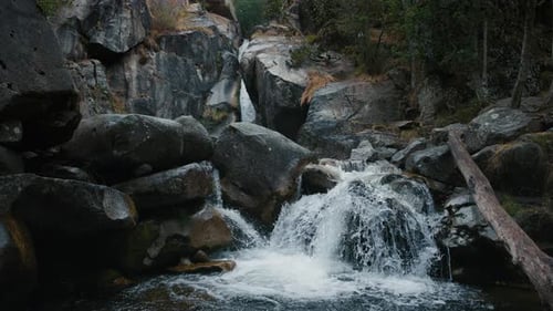 Fließendes Gebirgsflusswasser auf Felsen am Bergwasserfall in Zeitlupe
