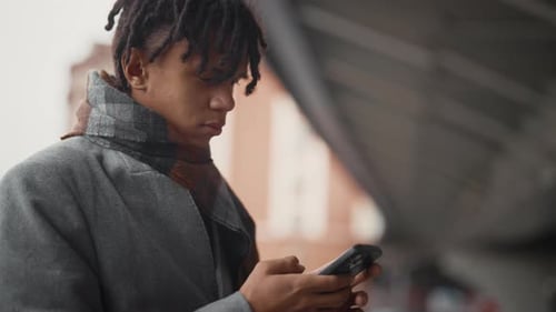 Young African Man Using Smartphone on City Street Male User of Mobile Phone Portrait of Black Guy