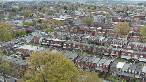Aerial of urban city in USA during spring season. Establishing daytime shot. Homes and residences al