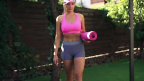 Athletic Woman Walking with Yoga Mat Outdoors