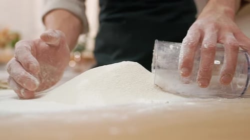 Hands Kneading Flour on Wooden Table