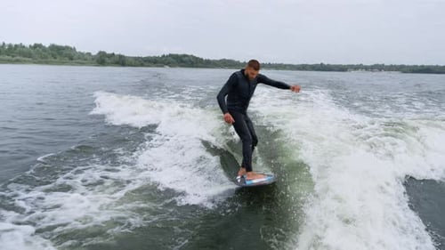 Male Wake Surfer Riding Waves on Lake