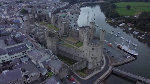 Ancient Caernarfon castle Welsh harbour town aerial view medieval waterfront landmark right overlook
