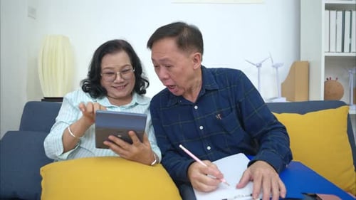 On a holiday, an elderly couple is relaxing at home, keeping a record of household