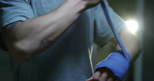Adult Wraps Hands with Blue Bandage for Sports