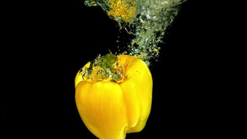 Gelbe Paprika fällt unter Wasser, gefilmt mit einer Hochgeschwindigkeitskamera mit 1000 Bildern pro Sekunde
