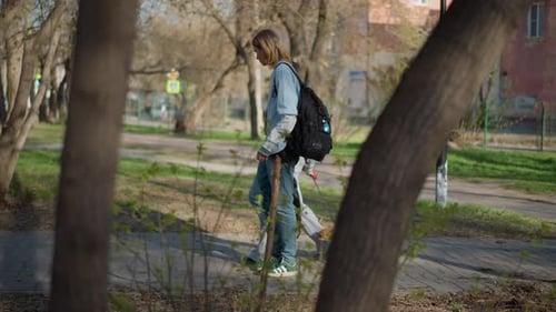 Young Couple Walking Dog in Park on Sunny Day