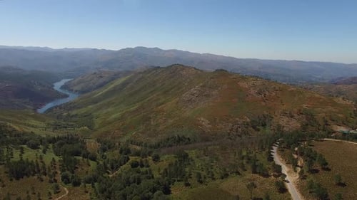 Cinematic Drone View of Winding River Through Lush Green Valley