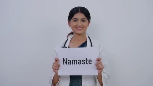 Doctor Holds Namaste Sign Smiling at Camera