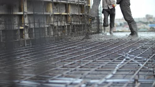 Workers Pouring Concrete at a Construction Site