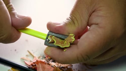 Footage of hands slowly sharpening a pencil and some coloured pencils with a Wedge Pencil Sharpener.
