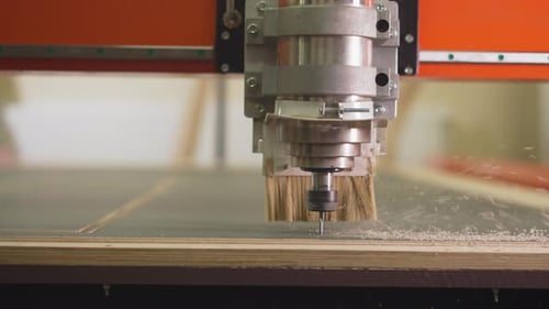 Wood Lathe Machine Cuts Out Line in Plywood Sheet in Shop