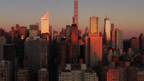 Epic aerial trucking shot of Manhattan New York City at sunrise golden hour (from the East River)