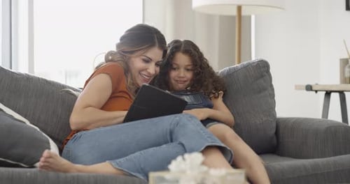 Woman and Child Using Tablet Together on Couch