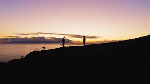 People Hiking on Mountain Top at Sunset