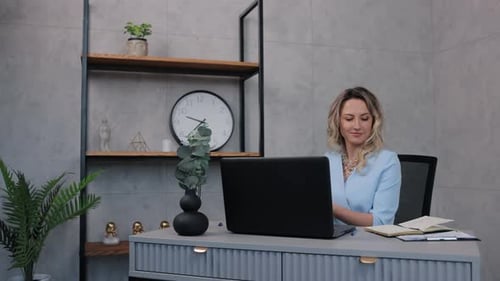 Woman Working at Desk Talking on Phone
