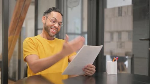 Young Adult Smiling While Reviewing Document