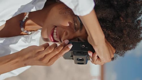 Happy Girl Taking Picture on Sandy Beach Portrait Vertically Black Haired Woman