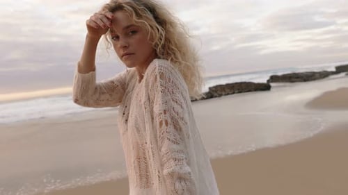 Blonde Young Woman Dancing on a Beach at Sunset Embracing Freedom