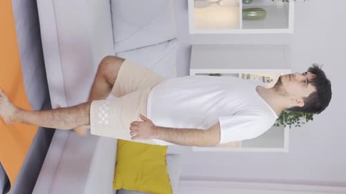 Young Adult Stretching Leg Indoors on Yoga Mat