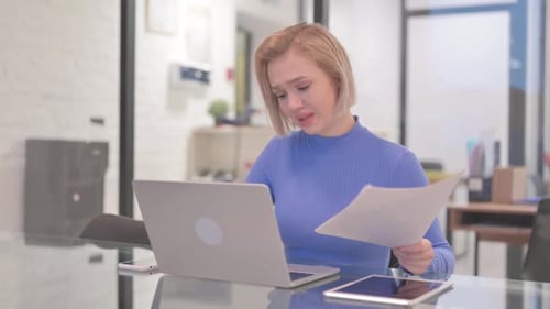 Worried Woman Working at Desk with Laptop