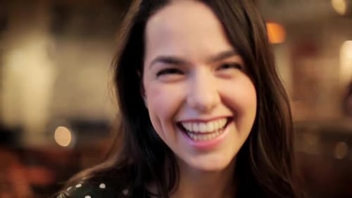 Close up of cheerful young woman smiling indoors