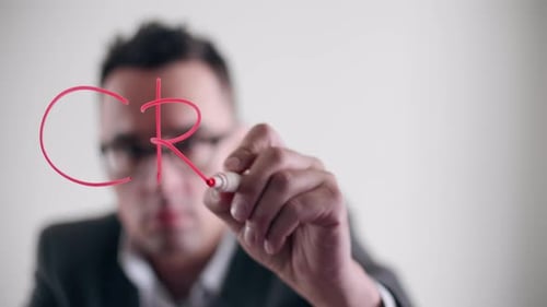 Adult Writes the Word Crisis on Clear Surface