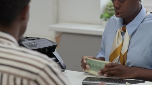 Teller Counting Banknotes in Electronic Device before Giving to Client in Bank