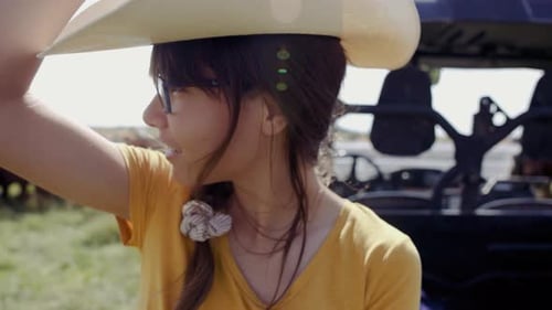 Close Up Smiling Girl Putting on Cowboy Hat on Cattle Ranch 10 Seconds or Greater