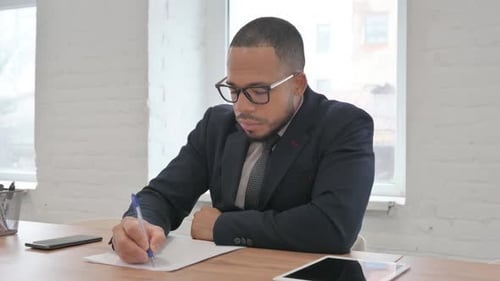 Mixed Race Businessman Writing a Letter in Office