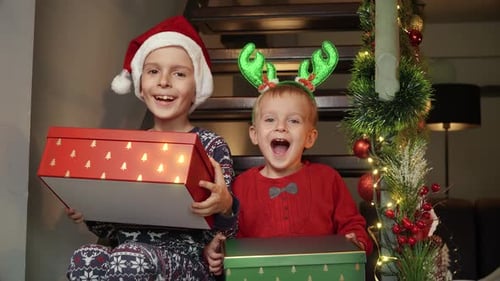 Happy Children Celebrate Christmas with Gifts at Home