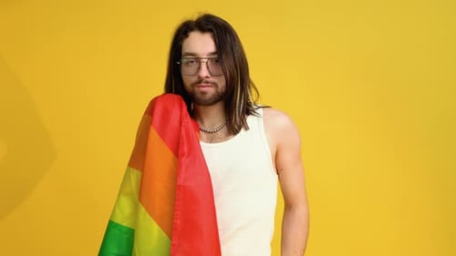 Young Adult Holding Pride Flag in Studio