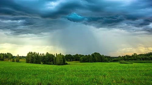 Time-lapse of a dramatic sunset clouds and a rain shower moving over the countryside