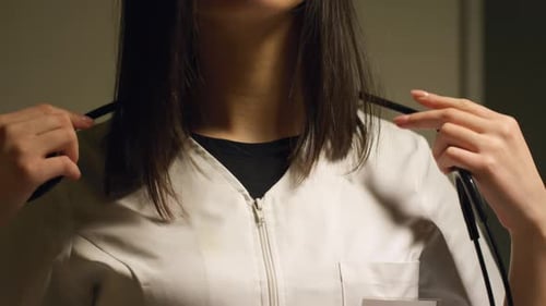 Female Doctor Putting on Stethoscope in Hospital