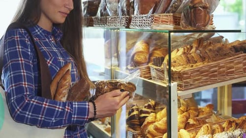 Female Customer Exploring Delicious Cookie Options at the Bakery