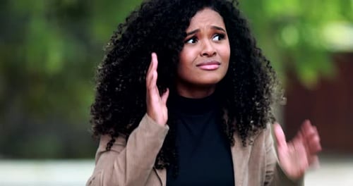 Woman Reacts Emotionally with Hands on Her Head