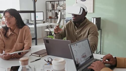 Black Businessman Working on Project Using AR Glasses and Laptop
