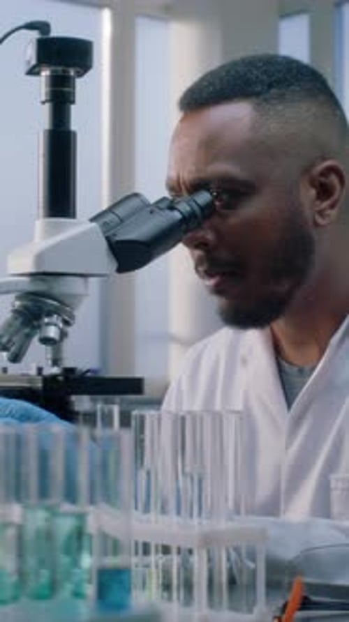 Scientist Uses Microscope in Modern Laboratory