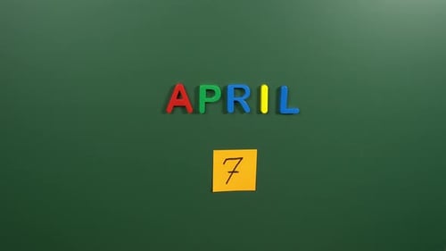 Hand sticking a sticker 7 April calendar day on school board. 7 date of April. Seventh day Apri
