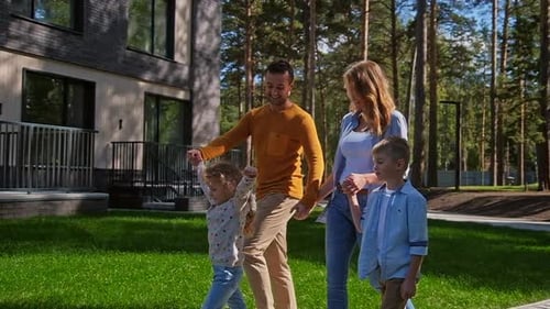 Happy Family Strolling Together Near Modern Suburban Home