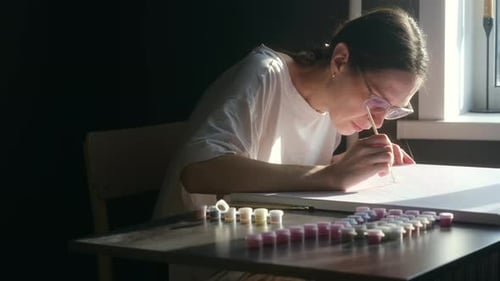 Woman Concentrating on Painting by Numbers at Home
