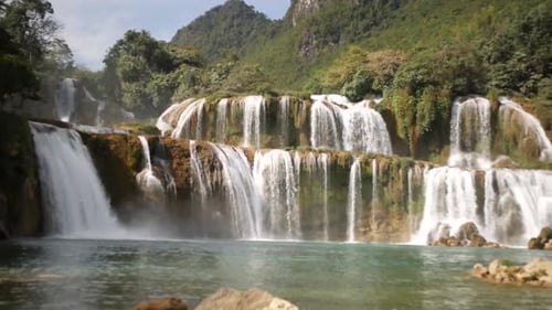 Girl Sitting On The Rock With Beautiful Ban Gioc - Detian Falls (Cao Bang Waterfall) In Vietnam At T