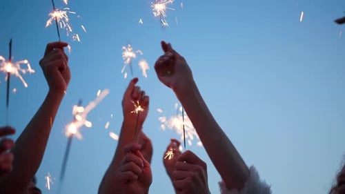 Friends Celebrating Holding Sparklers Up in Sky