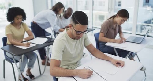 Students, writing and notes in lecture at university for learning, education