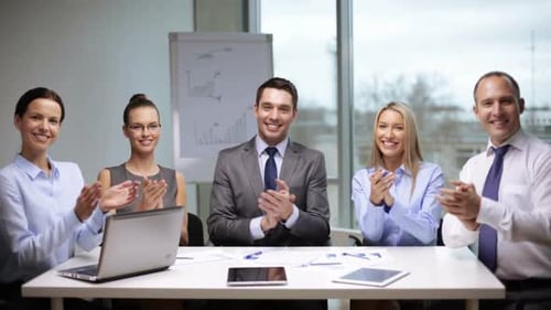 Successful teamwork in the office as business people applaud after meeting