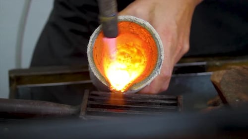 Molten Metal Poured into Mold by a Worker