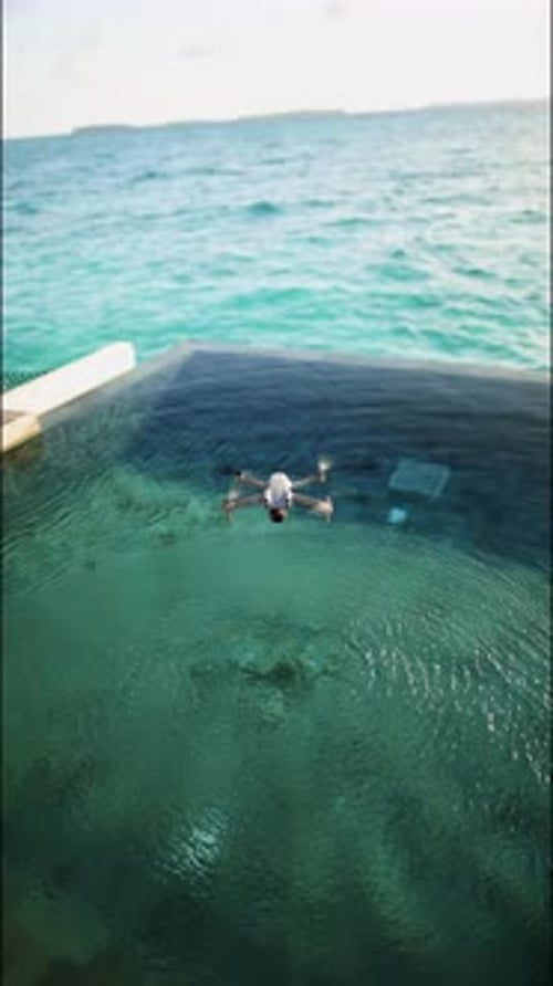 A Drone Flies Over a Swimming Pool in the Maldives Vertical Footage